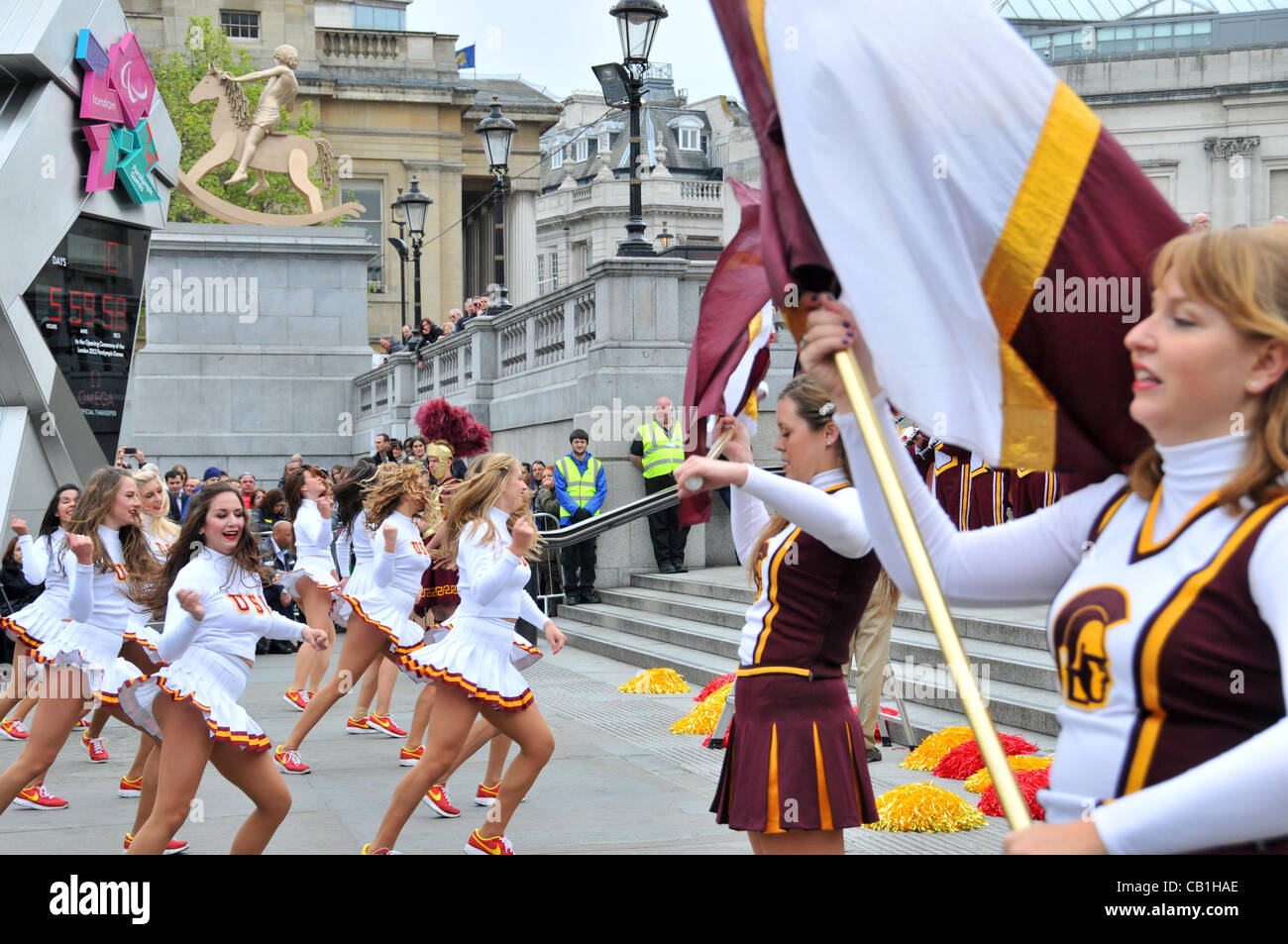 Cheerleaders de l'Université de Californie du Sud (USC), l'équipe de football de Troie Marching Band en face de l'horloge olympique à Trafalgar Square. Dimanche 20 Mai 2012 Banque D'Images