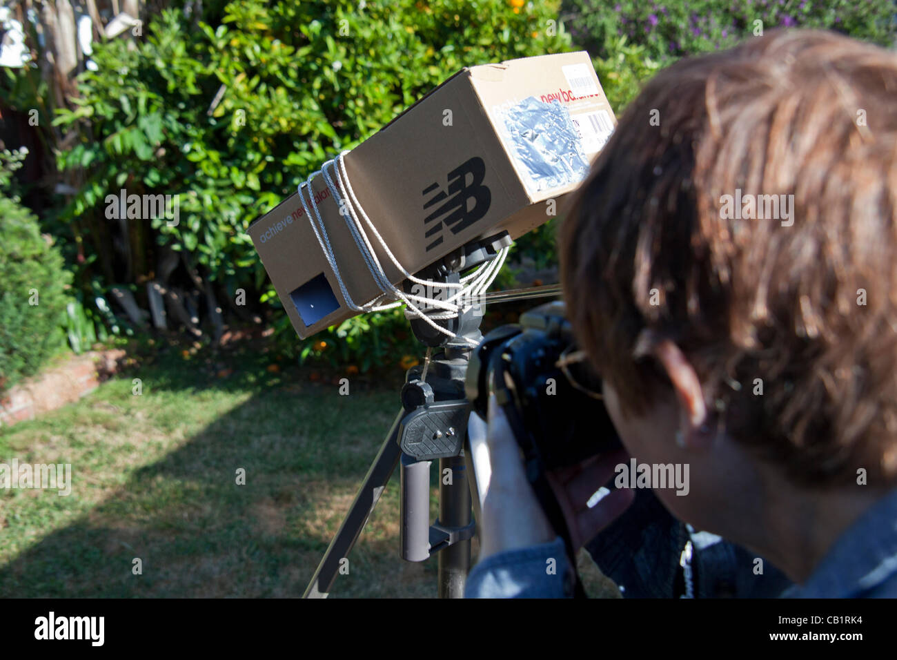 Sharon de San Leandro, Californie, utilise un sténopé maison viewer fait à partir d'une boîte à chaussures et lié à un trépied pour photographier des images du 20 mai 2012, éclipse de soleil à partir de son arrière-cour. Banque D'Images