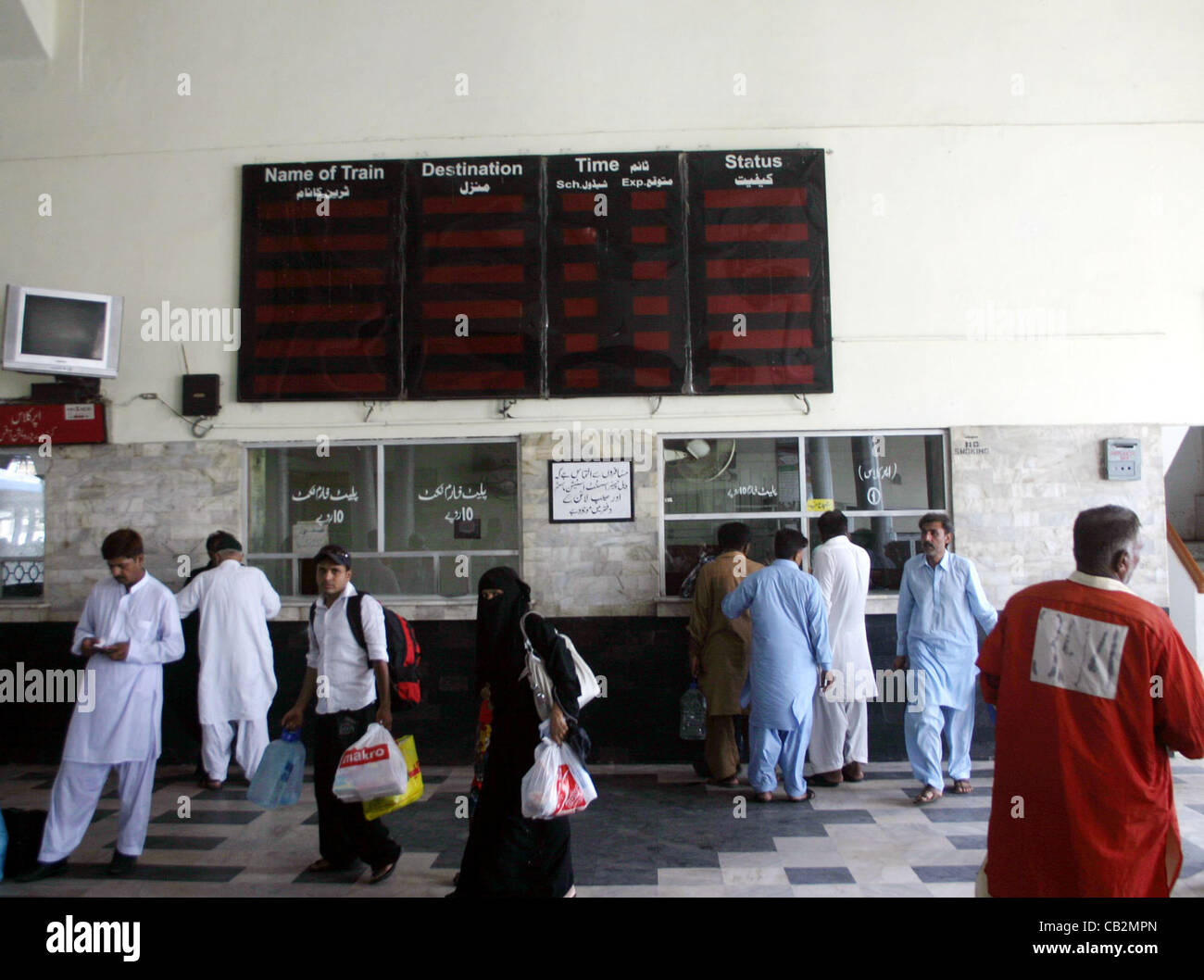 Retrouvez les passagers comme l'annexe des trains de voyageurs qui arrivent plus tard à la gare de Cantt à Karachi le vendredi 25 mai 2012. Banque D'Images