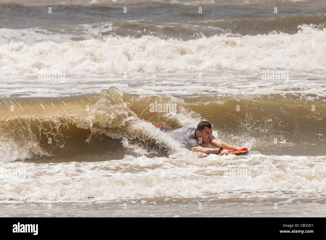 USA. Une plage goer body surf grosses vagues comme la tempête tropicale Beryl pinceaux passé la côte de la Caroline du Sud le 27 mai 2012 dans la région de Folly Beach en Caroline du Sud. La tempête a provoqué les plages locales à limiter la baignade en raison de forts courants et de marées sur le rip et populaires week-end du Memorial Day. Banque D'Images