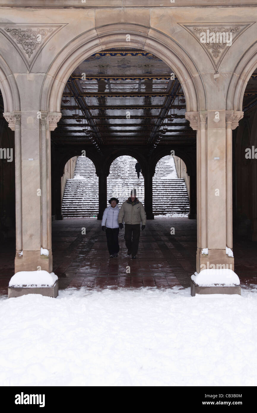 Un couple marche à travers l'Arcade Terrasse Bethesda dans Central Park à New York l'hiver Banque D'Images