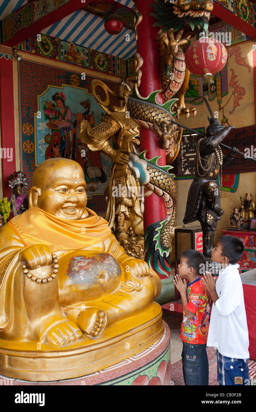 Thaïlande, Bangkok, Chinatown, les enfants priant à Buddha statue Banque D'Images