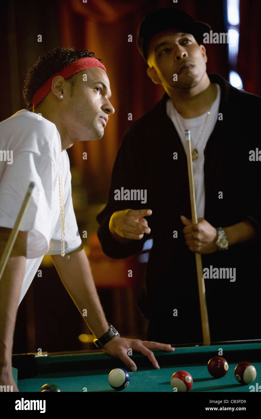 Les jeunes hommes jouant au billard dans la salle de billard Banque D'Images