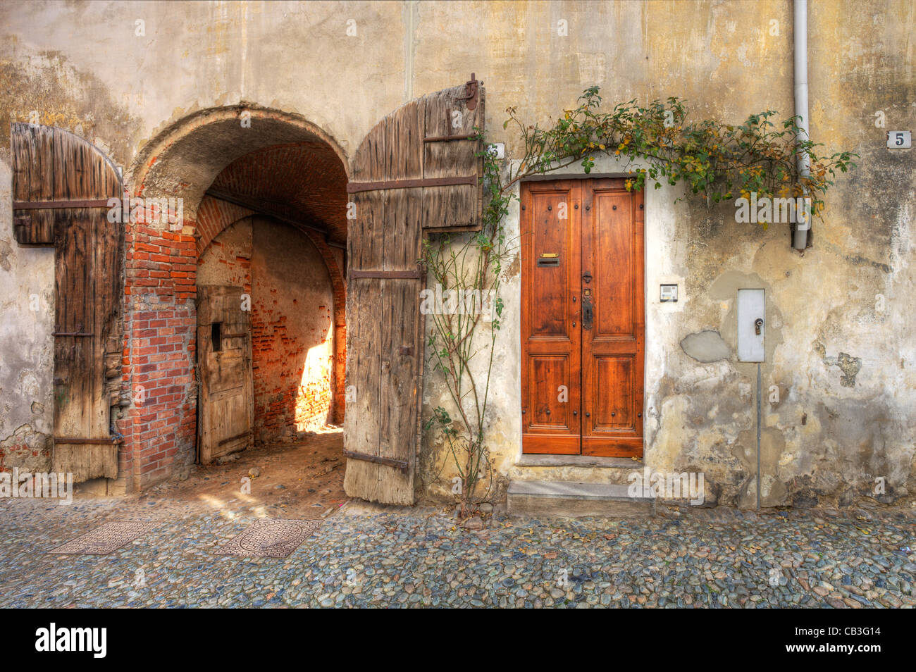 Porte en bois et porte d'entrée de garage à l'ancienne maison de brique de la ville de Saluzzo, Italie du nord. Banque D'Images