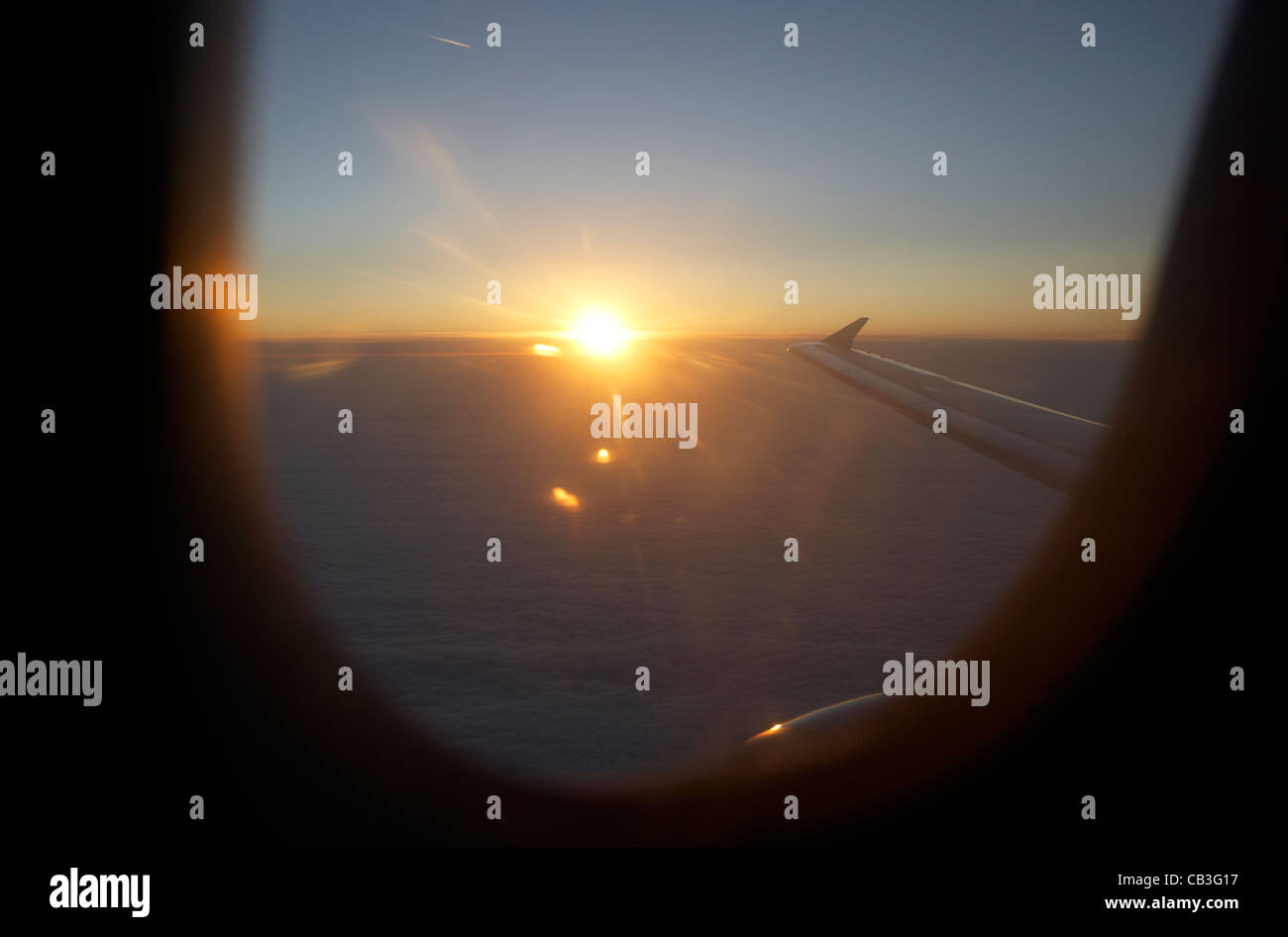 Lever du soleil à travers la fenêtre de l'avion de passagers durant le vol le vol de l'effet yeux rouges la traversée de l'Atlantique Banque D'Images
