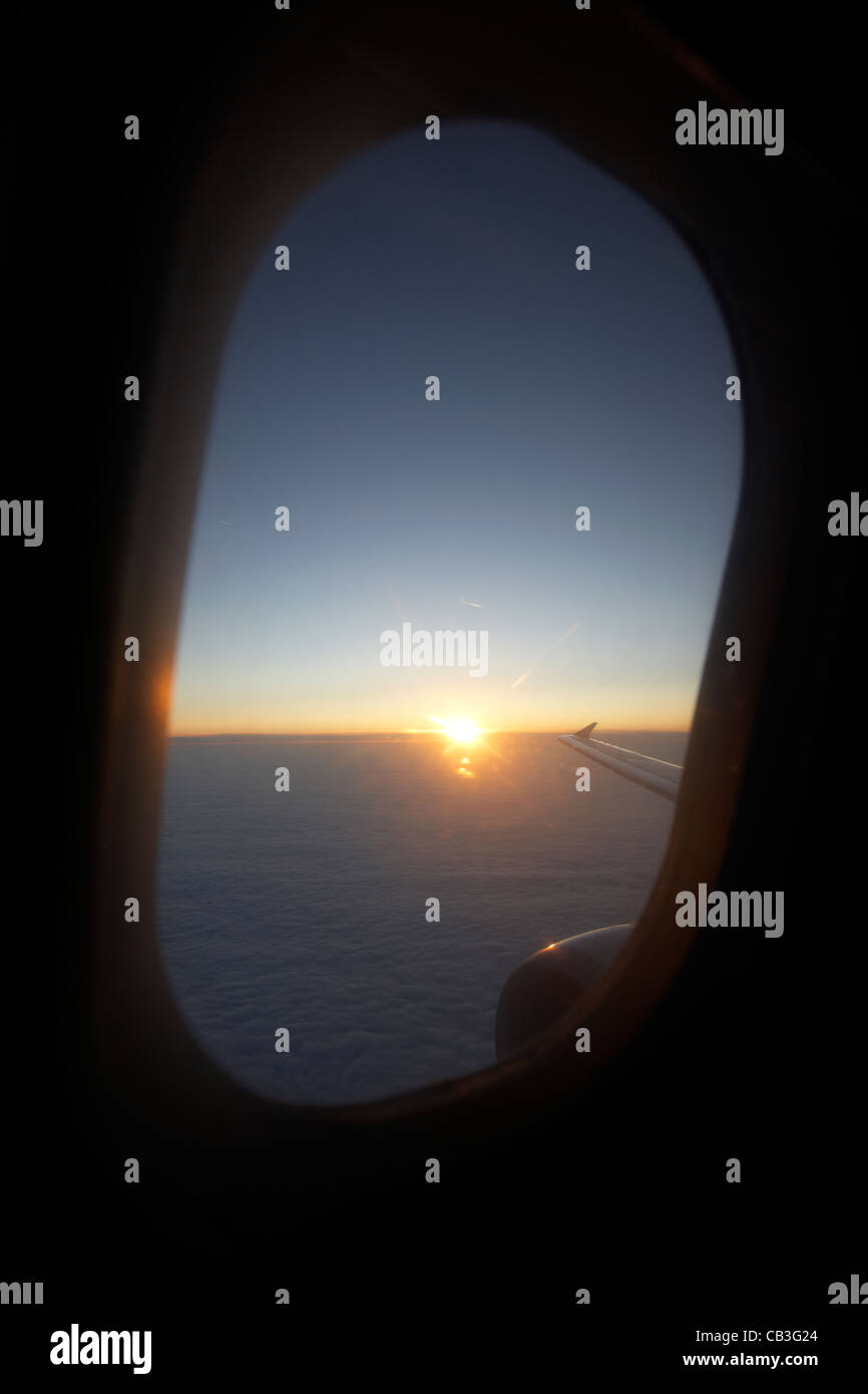 Lever du soleil à travers la fenêtre des aéronefs de passagers pendant le vol. Banque D'Images