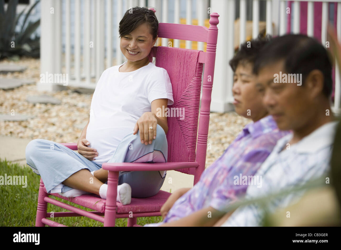 Femme enceinte assise sur un rocking-chair avec ses parents en premier plan  Photo Stock - Alamy