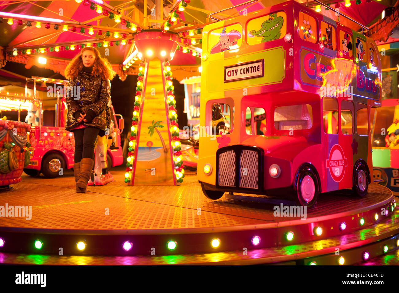 Une jeune adolescente à ennuyer à travailler sur un tour à la foire annuelle de novembre fête foraine d'Aberystwyth, Pays de Galles UK juste Banque D'Images