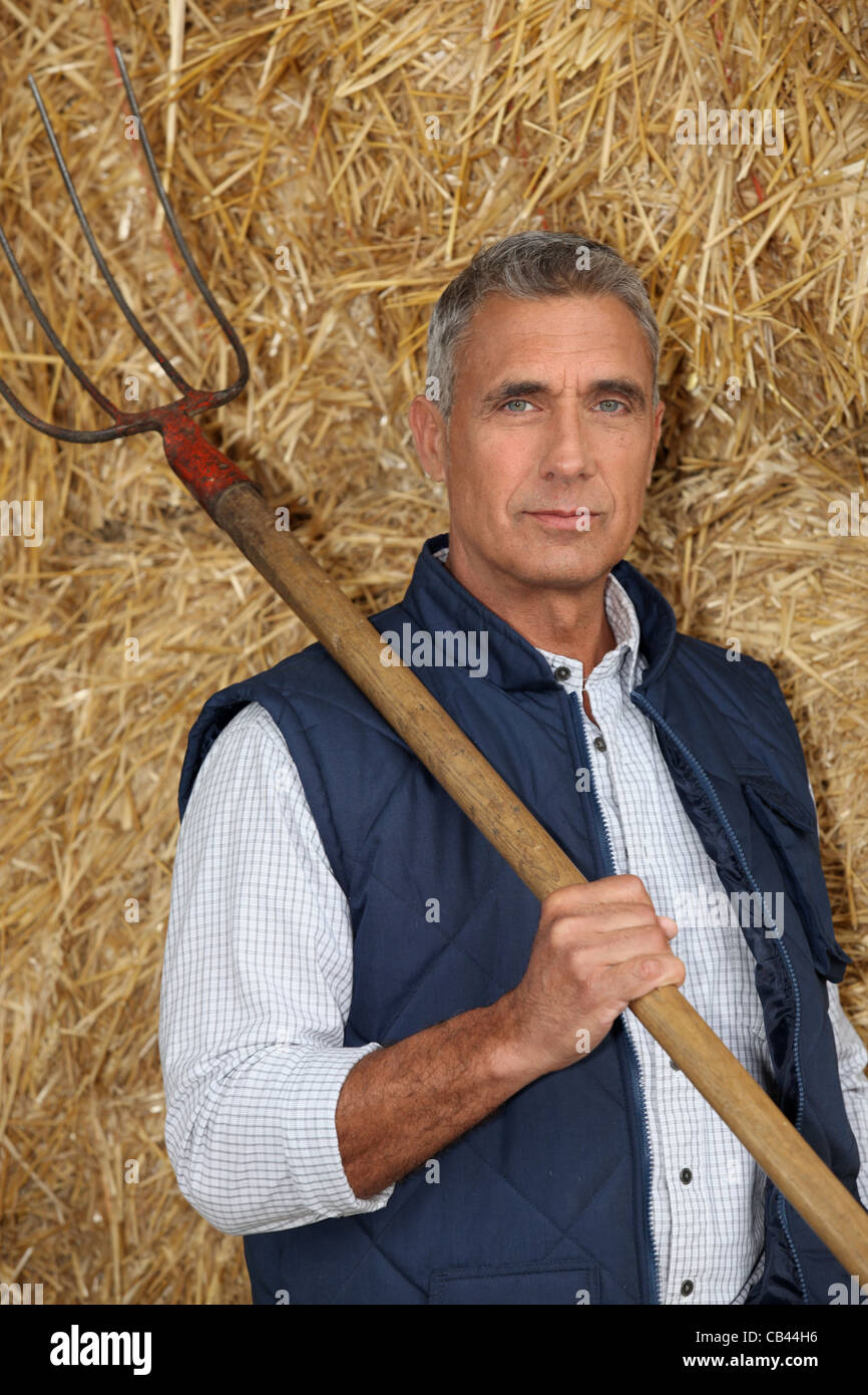 Agriculteur détenant une fourche Banque D'Images