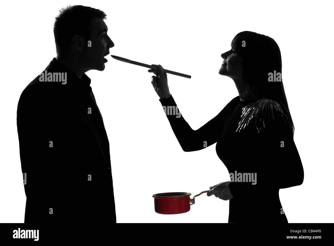 Un couple homme et femme cuisine dégustation casserole en silhouette studio isolé sur fond blanc Banque D'Images