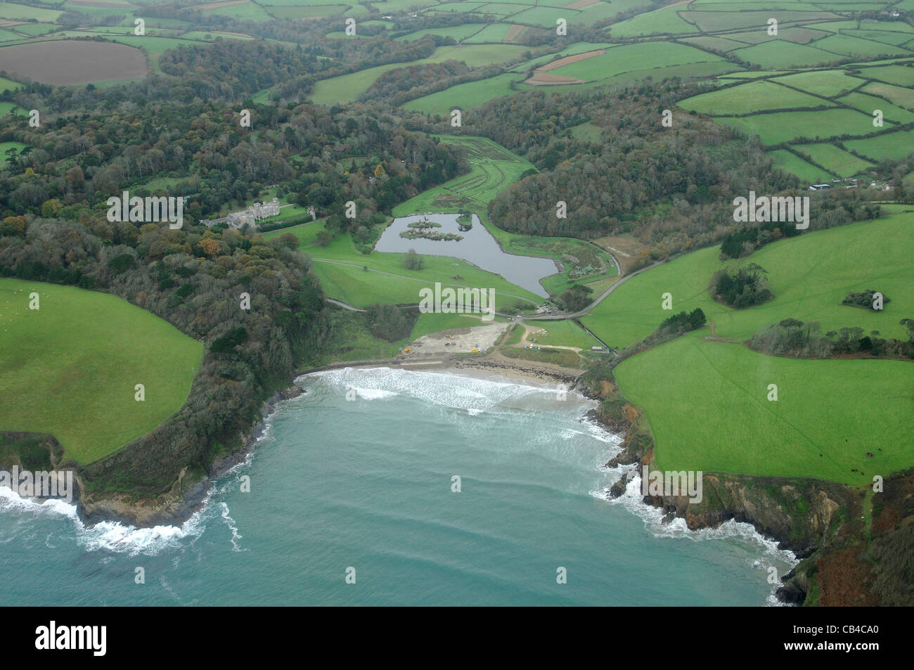 Situé dans un superbe emplacement en retrait de crique de Porthluney Cove, Château de Caerhays bénéficie de vues spectaculaires sur la côte sud de Cornwal Banque D'Images