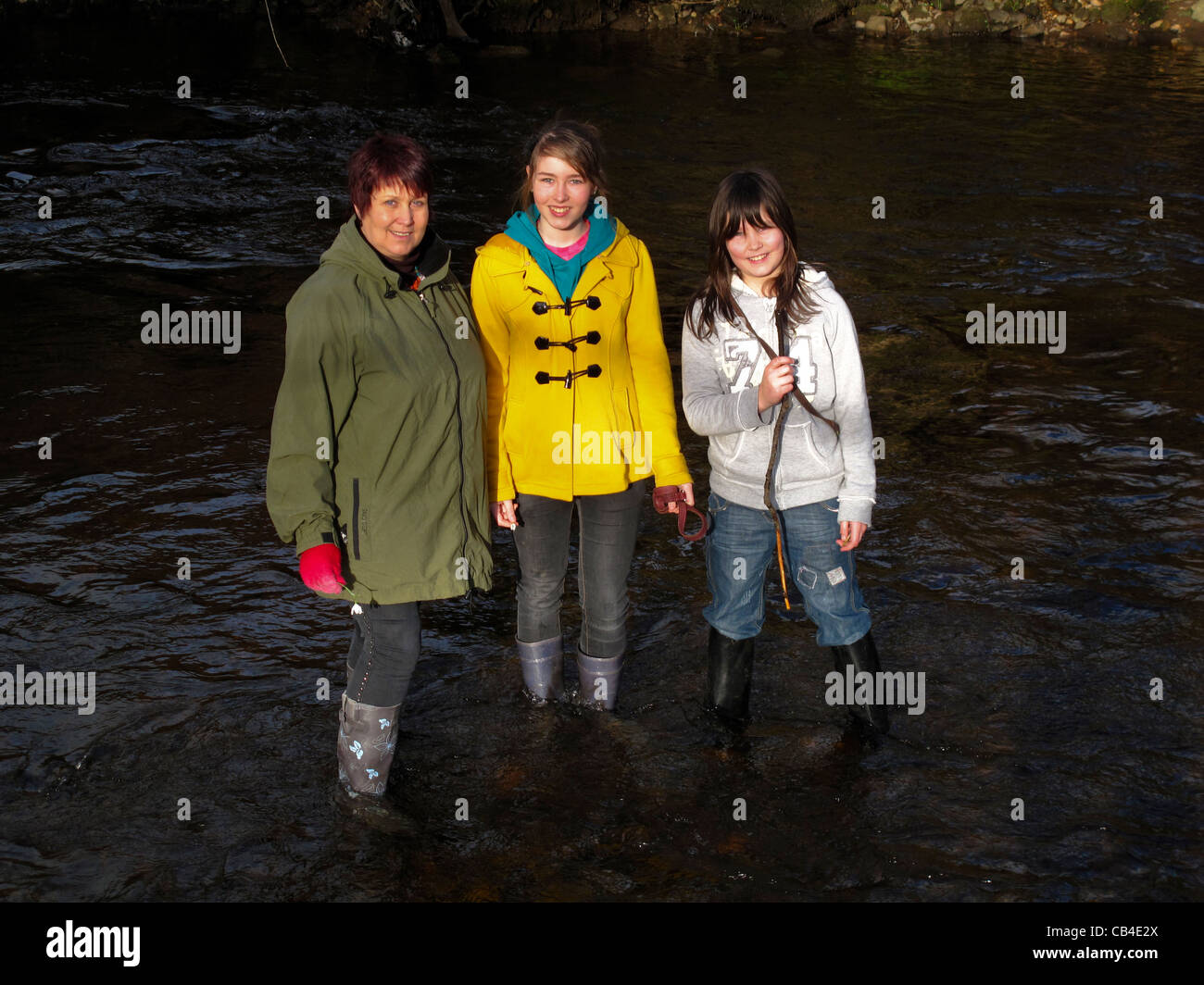 La mère et les filles en pagayant dans la rivière bottes wellington Banque D'Images