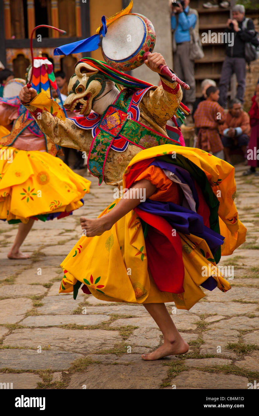 Une danseuse avec un loup un masque et un costume coloré fonctionne à l'avril 2010 Domkhar, Bhoutan festival Banque D'Images