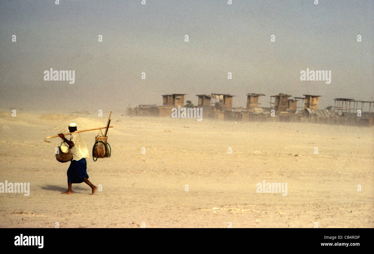 Un travailleur migrant pauvre qui rentre à la maison à travers une tempête de sable dans le désert, frontière Dubai-Sharjah 1975, Émirats arabes Unis Banque D'Images