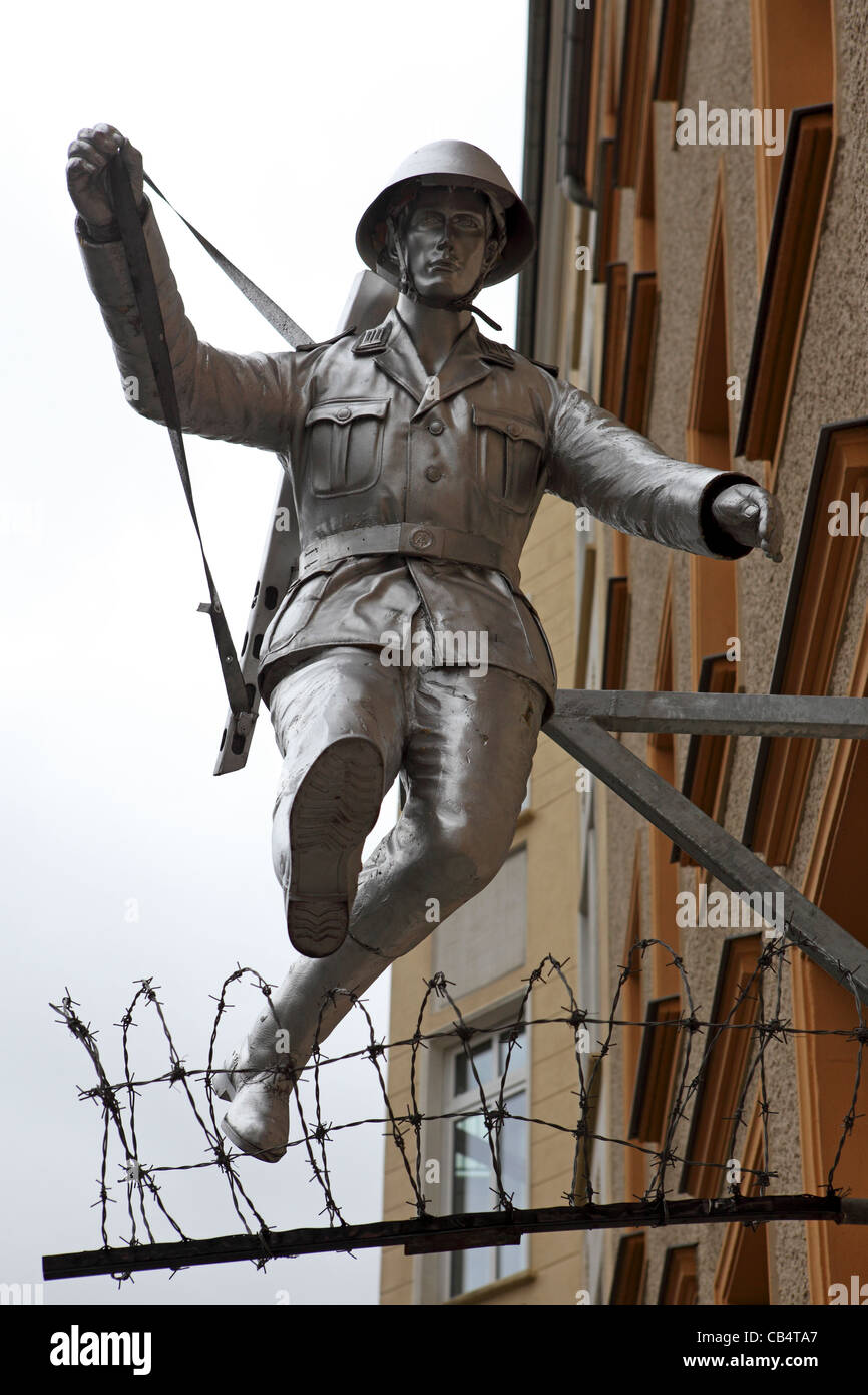 Sculpture d'un soldat de l'armée nationale populaire de sauter le tout nouveau mur de Berlin à la Bernauer Strasse à Berlin, Allemagne. Banque D'Images