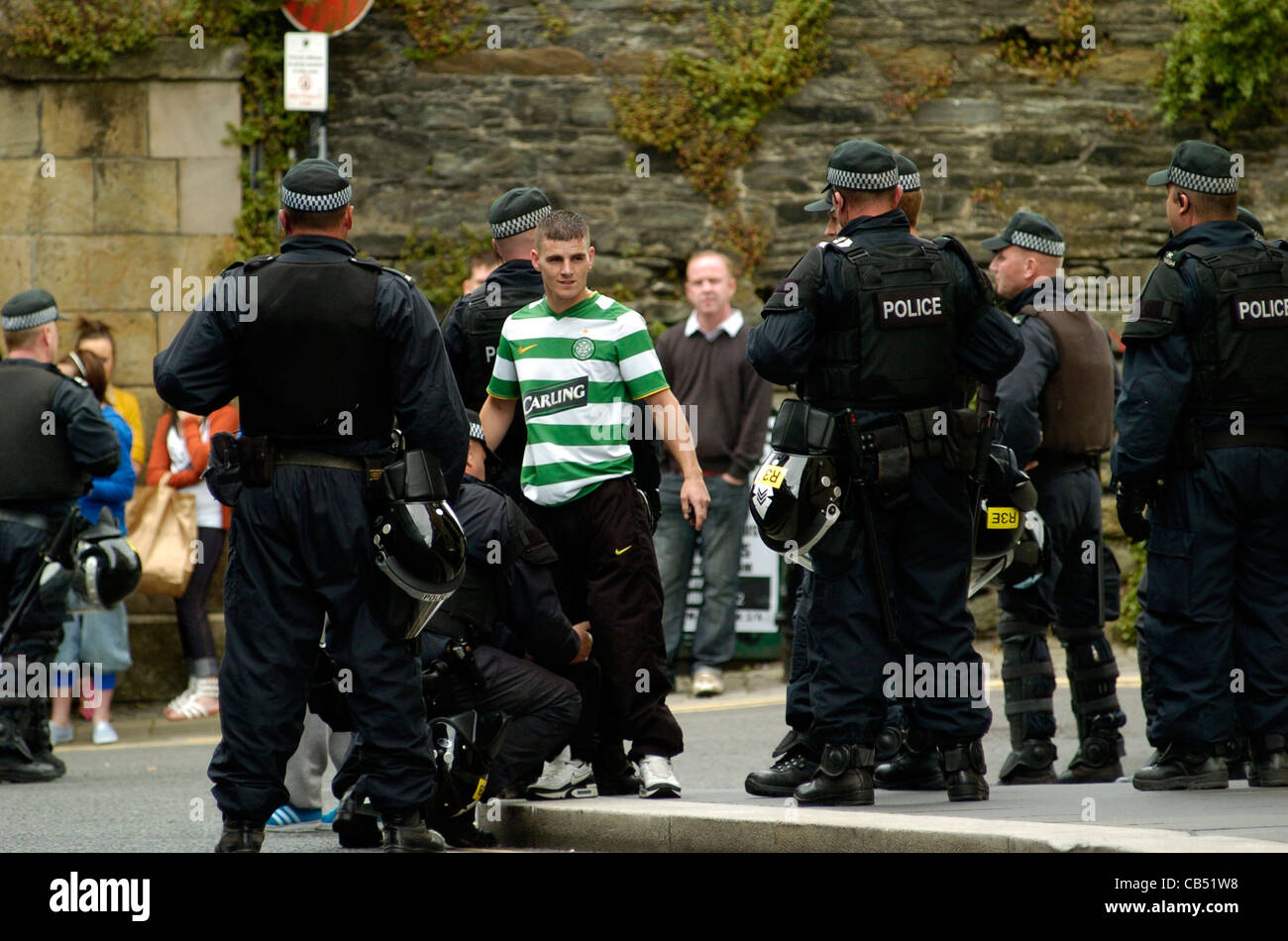 La jeunesse nationaliste, le port d'un maillot de football Celtic Glasgow, arrêté et fouillé par les agents à Londonderry PSNI. Banque D'Images