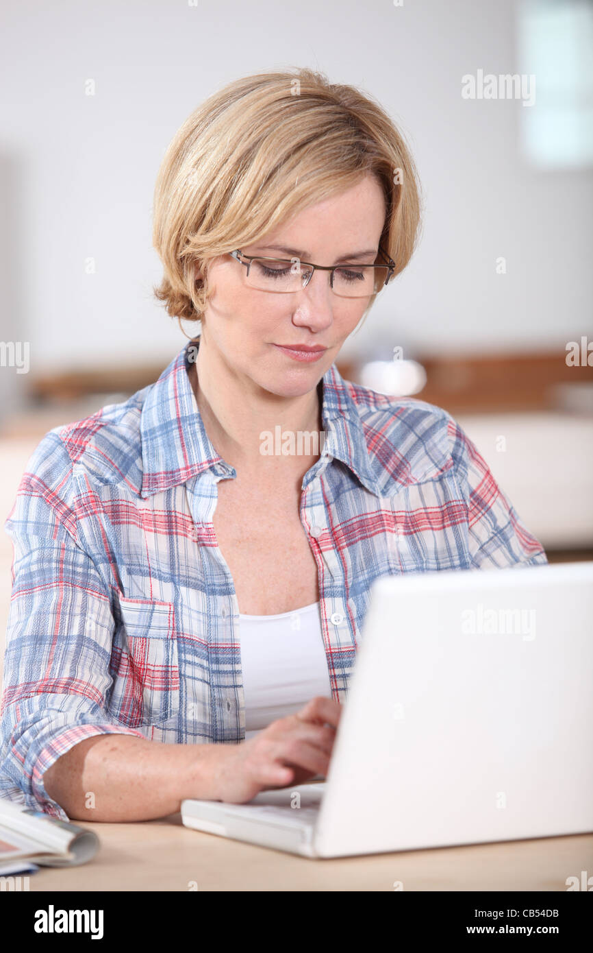 Femme utilisant un ordinateur portable à la maison Banque D'Images