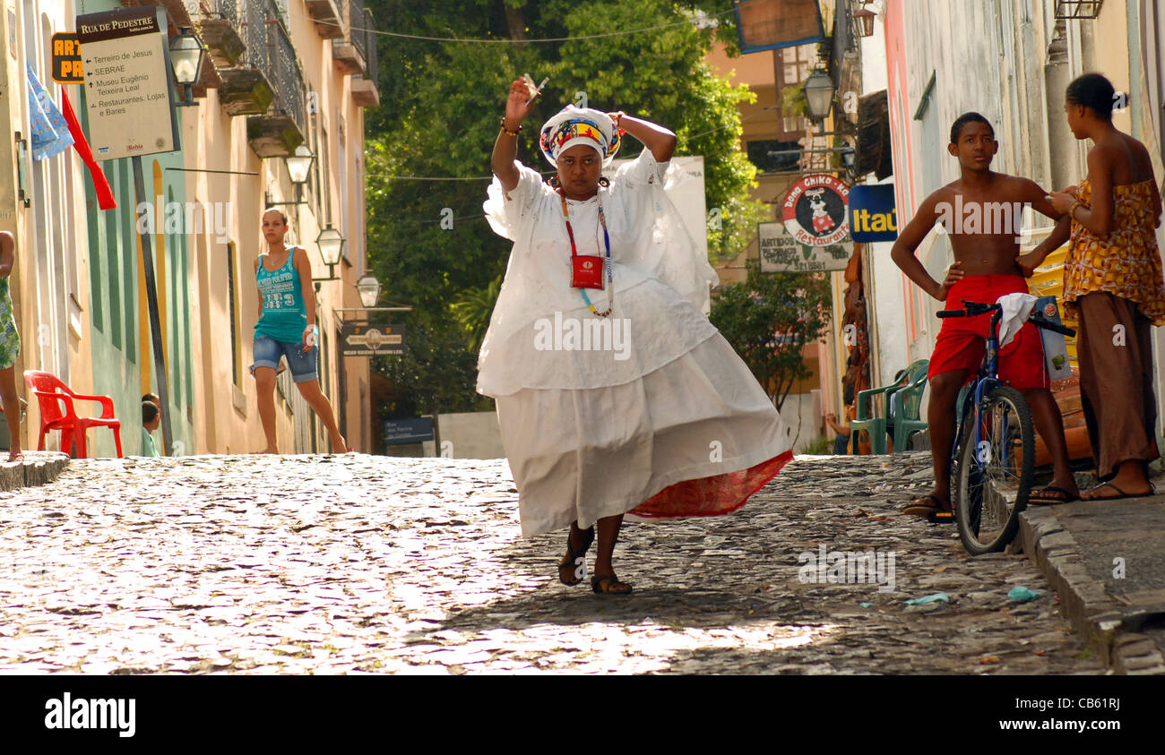Une femme en costume traditionnel se précipite DANS LA RUE DANS LE QUARTIER DE PILOURNINHO, Salvador, Brésil Banque D'Images