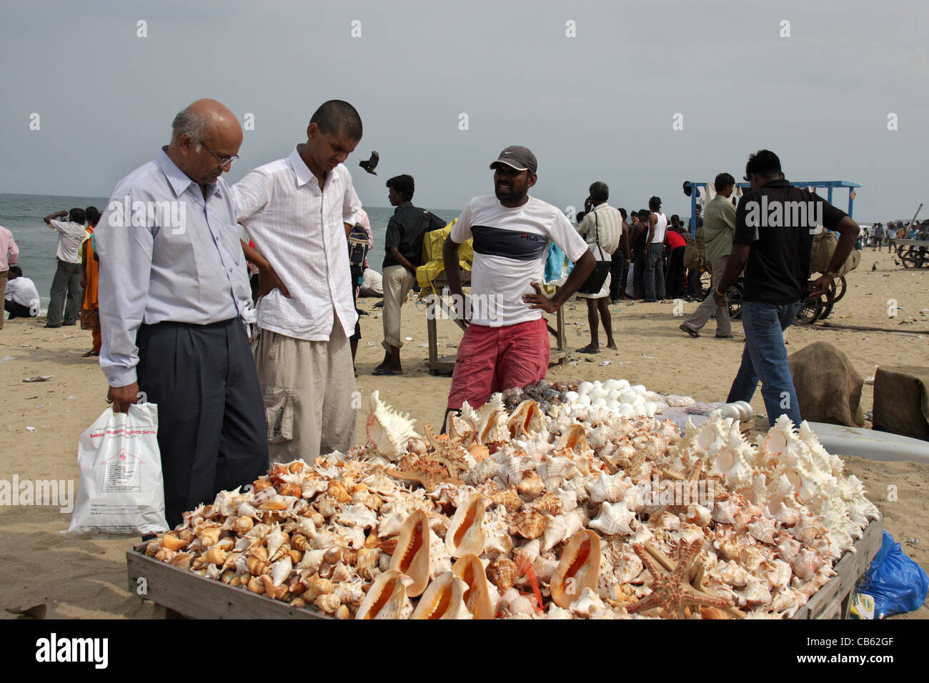 Les touristes d'acheter des coquillages et de la mer d'un vendeur de bibelots à marina beach, Chennai, Inde, Asie Banque D'Images