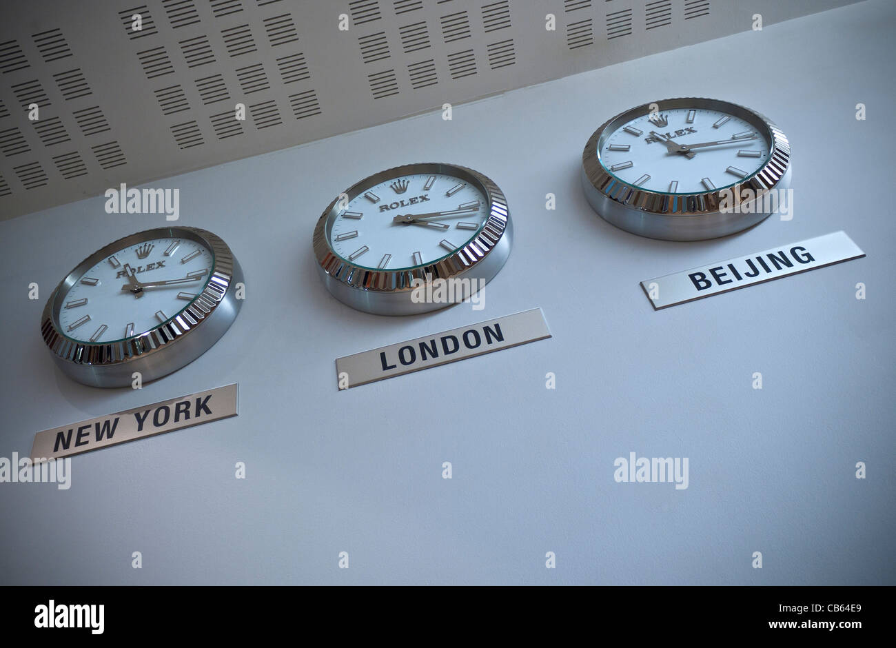 Fuseaux horaires INTERNATIONAL FINANCE BUSINESS trois horloges Rolex sur un mur blanc de New York, Londres et Pékin Banque D'Images