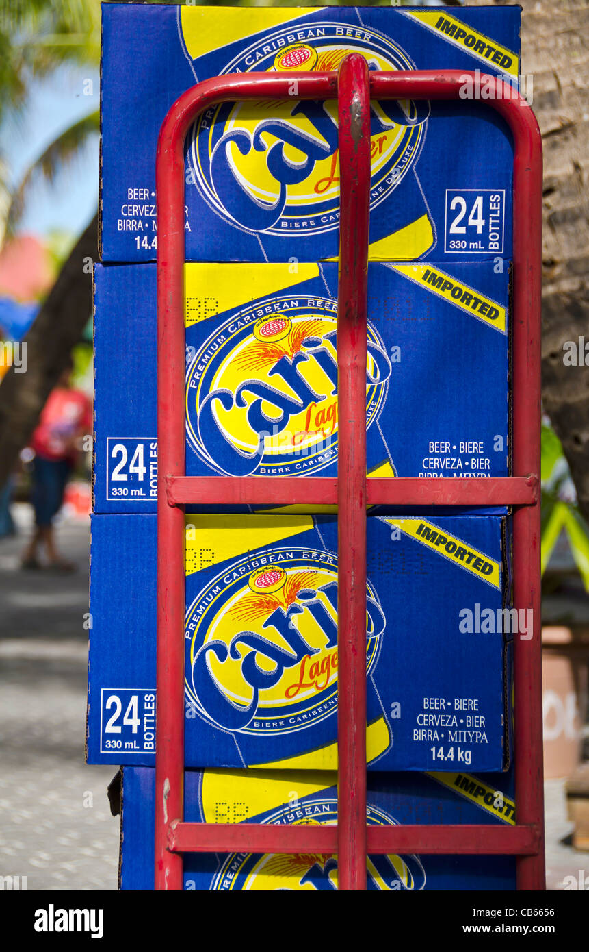 Les cas de la bière Carib empilées sur dolly rouge panier, St Maarten Banque D'Images