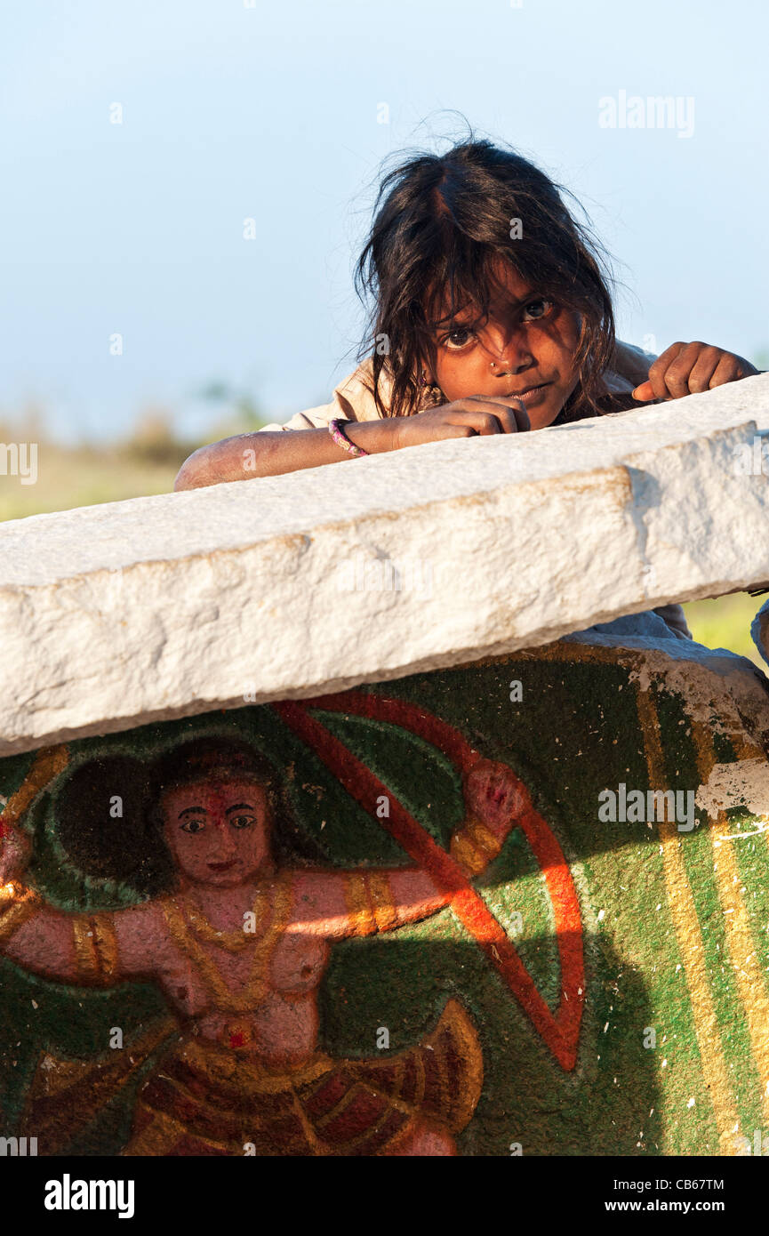 Les Indiens pauvres mendiant girl leaning on un village rural sanctuaire hindou. L'Andhra Pradesh, Inde Banque D'Images