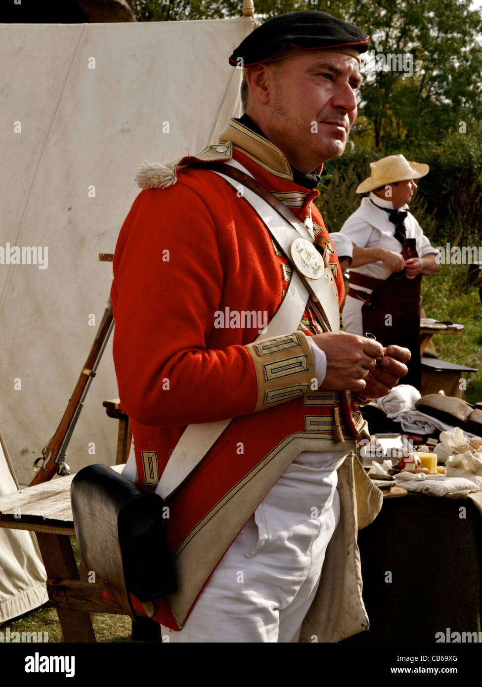 Une nouvelle reconstitution médiévale vêtu comme un 44e soldat du régiment Essex Est prend une pause à côté du chirurgien de l'armée. Banque D'Images