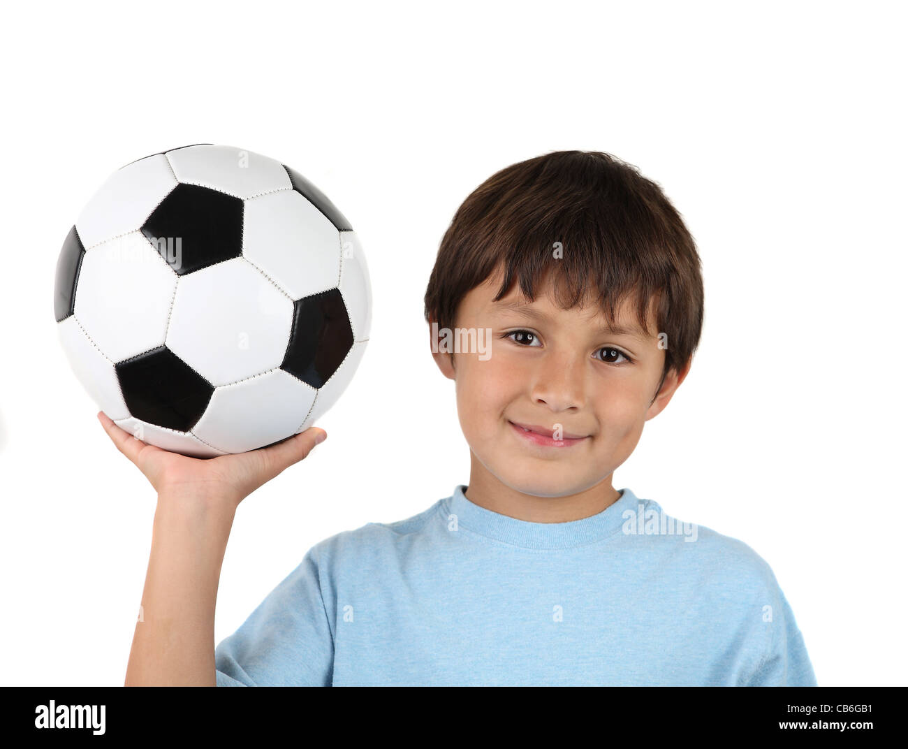 Young happy boy holding up ballon de soccer sur fond blanc Banque D'Images