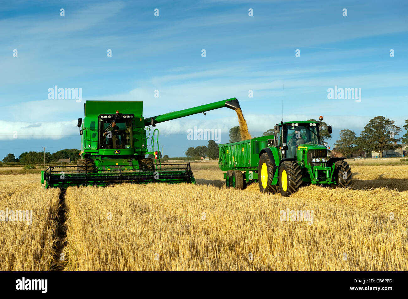 Moissonneuse-batteuse John Deere T690 dragées remorque d'tracteur, avec grain. Banque D'Images