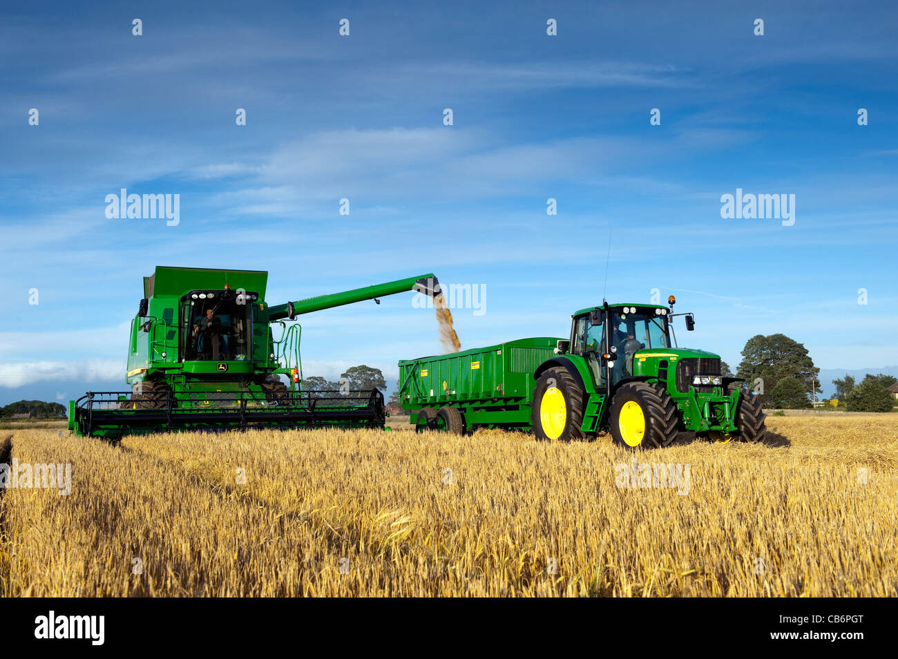 Moissonneuse-batteuse John Deere T690 dragées remorque d'tracteur, avec grain. Banque D'Images