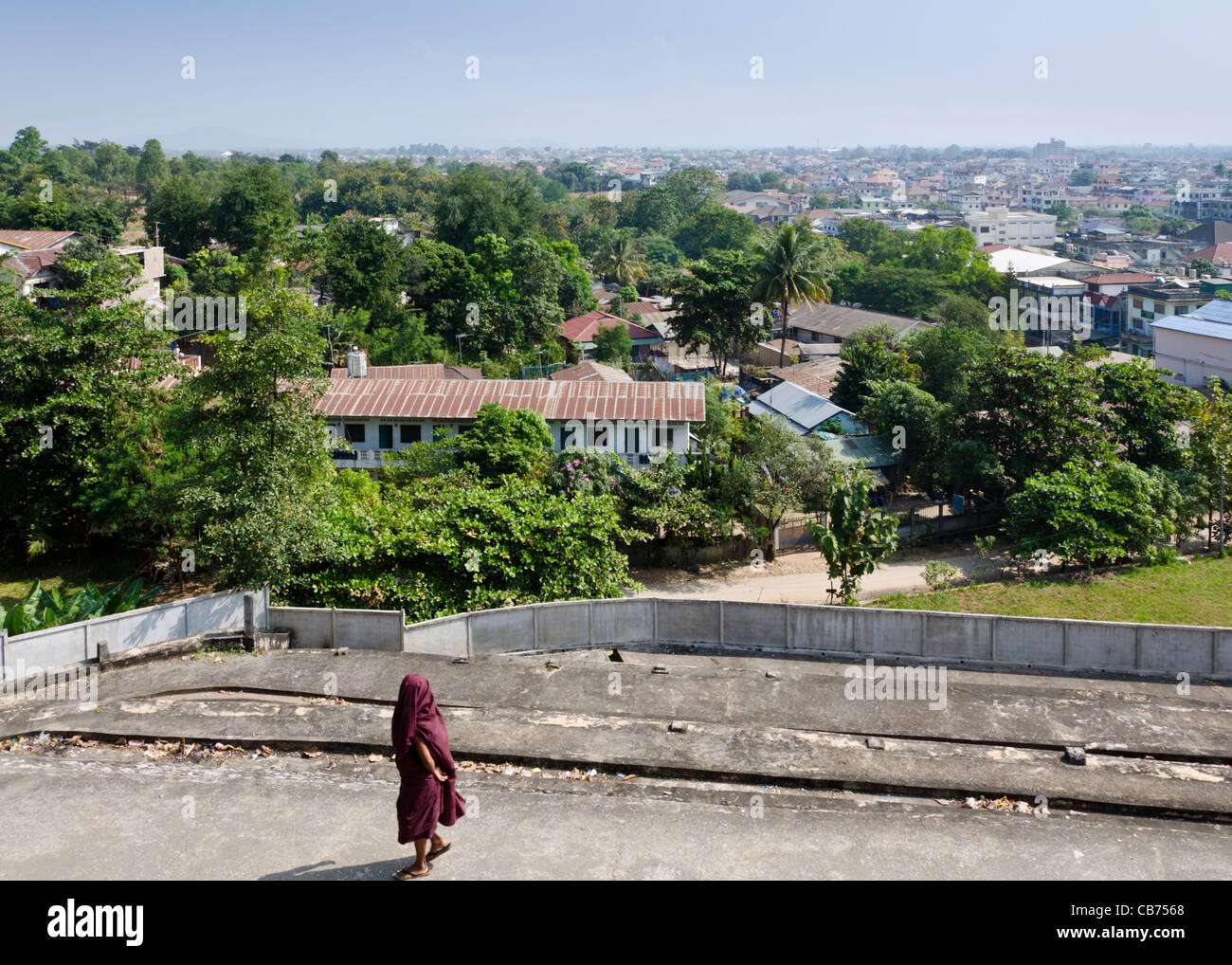 Porter robe marron bouddhiste tiré jusqu'à couvrir la tête le long de chemin de ronde surplombant Tachileik postfaces Myanmar (Birmanie) Banque D'Images