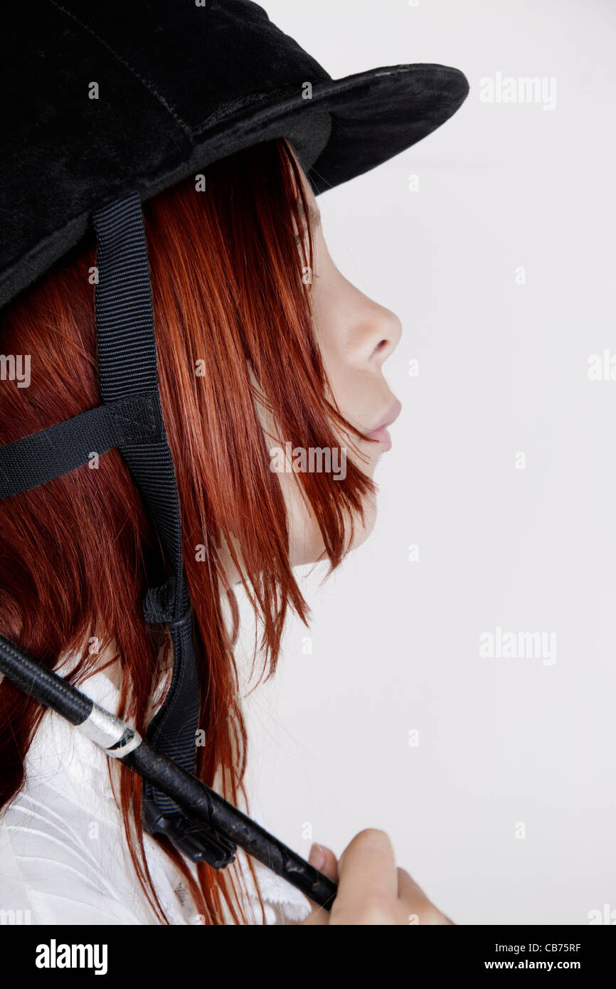 Red haired girl wearing Black Velvet riding hat Banque D'Images