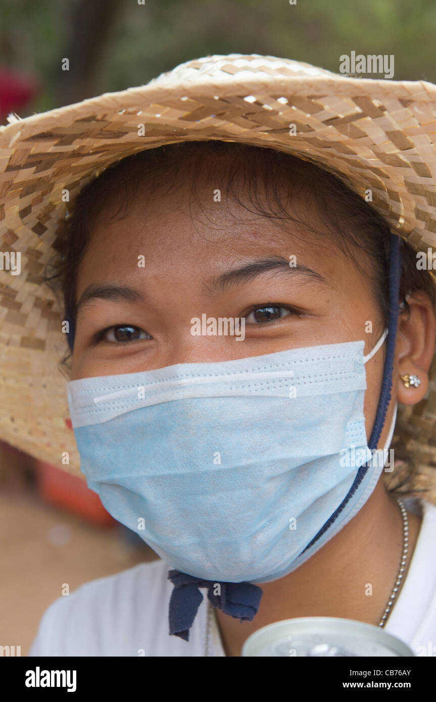 Femme khmère dans un masque chirurgical lors d'une fête de village, nouvel an cambodgien (Chaul Chnam Thmey), Bakong Village, Siem Reap, Cambodge Banque D'Images