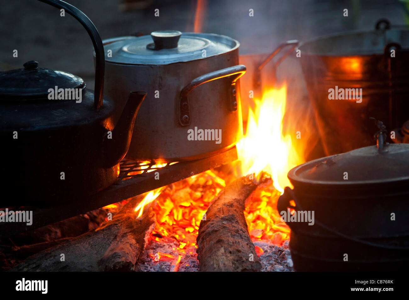 Dans l'eau bouillante et de l'alimentation électrique la cuisson dans des pots en métal sur feu de bois ouvert, Okavango Delta, Botswana, Africa Banque D'Images