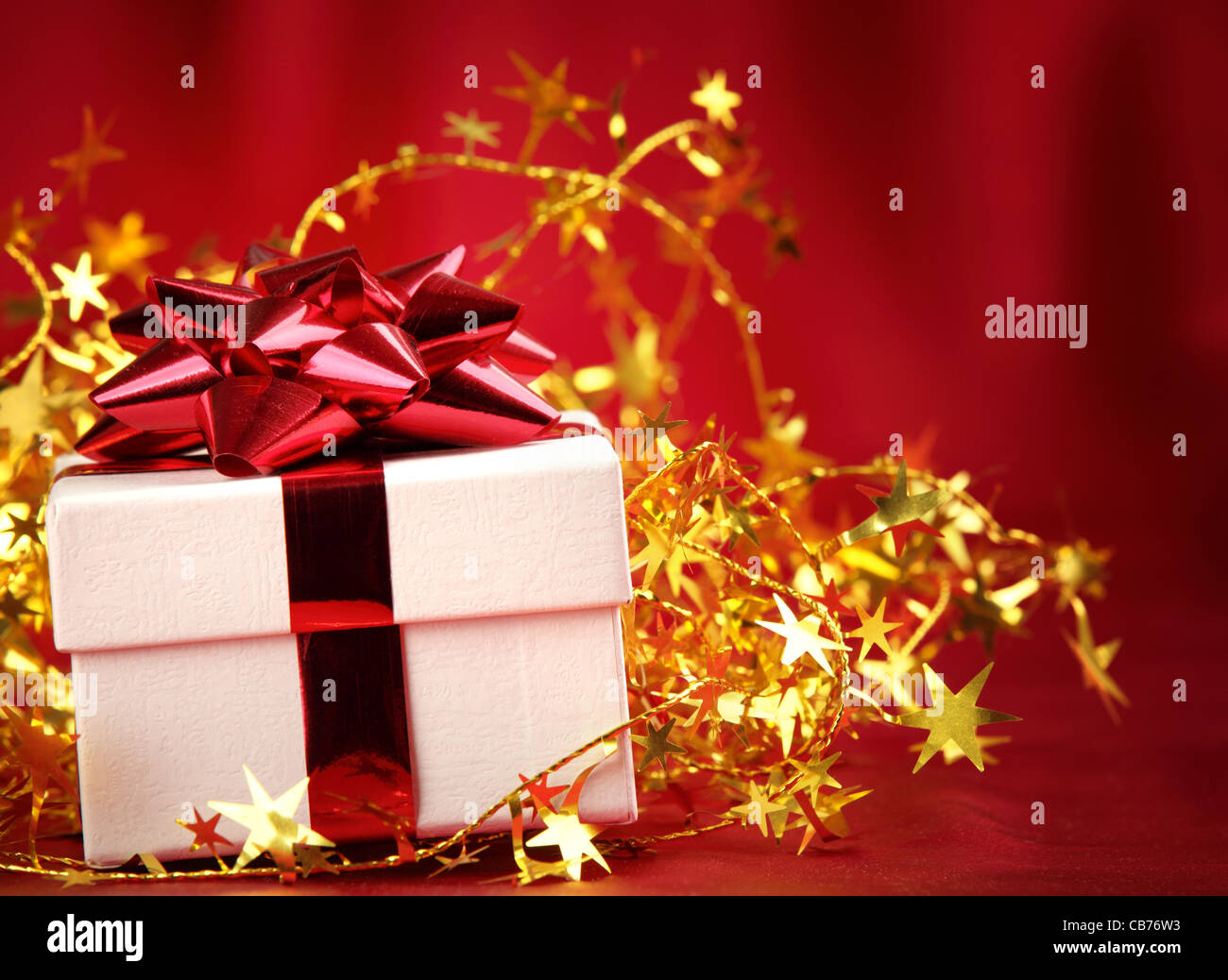 Cadeaux de Noël et clinquant étoiles sur fond rouge Banque D'Images