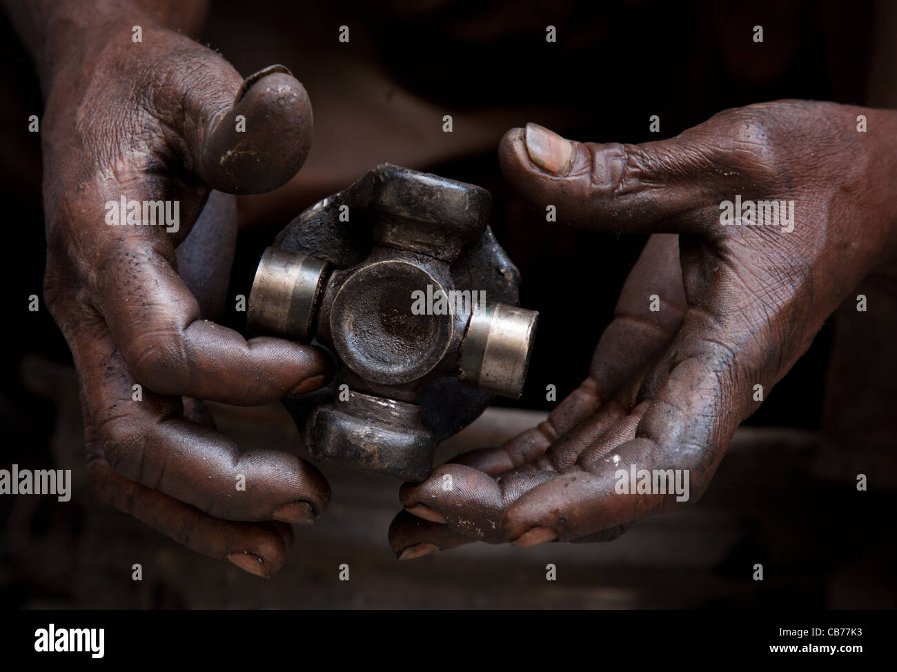 Les mains d'un mécanicien graissé une fixation de l'arbre de transmission, La Havane (La Habana, Cuba) Banque D'Images