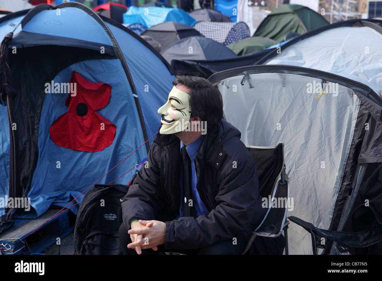 Campement Occupy London, à l'extérieur de la Cathédrale St Paul, London, UK. Homme , partie de mouvement anonyme portant le masque de Guy Fawkes Banque D'Images