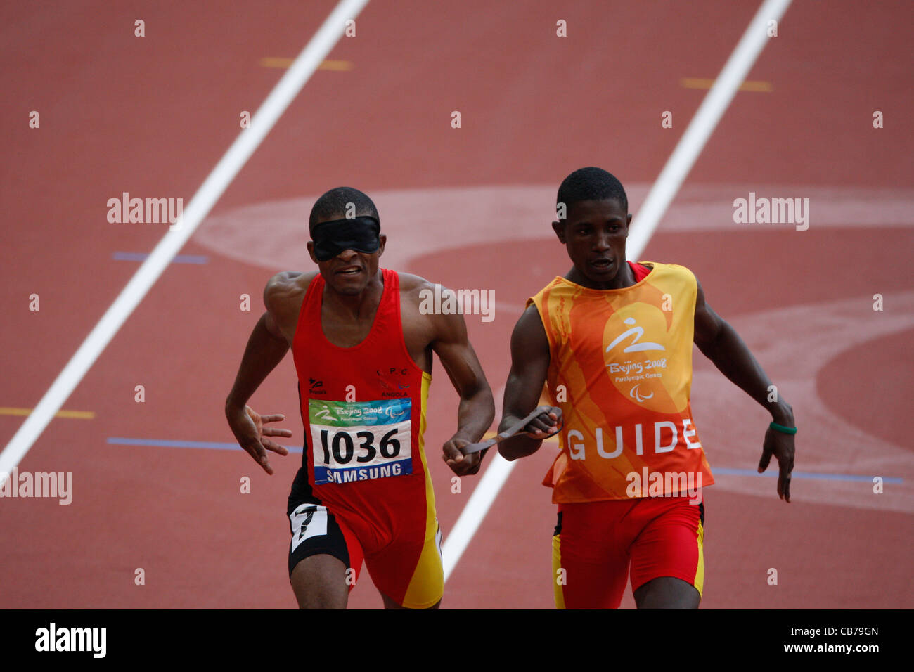 La compétition sportive aux Jeux paralympiques de 2008 montrant la finition runner angolais course pour les athlètes aveugles avec guide Banque D'Images