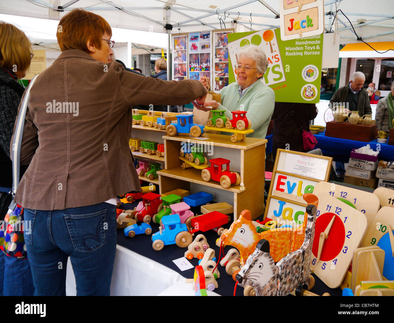 Les clients qui achètent des jouets en bois Made in Shrewsbury Shropshire Shropshire market stall Banque D'Images