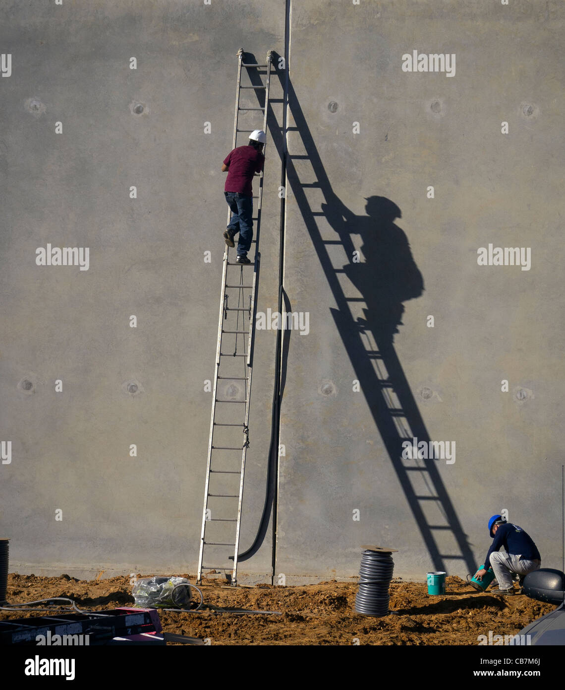 Workman sur l'échelle avec la lumière du soleil d'ombre. La vie est comme monter une échelle ? Banque D'Images