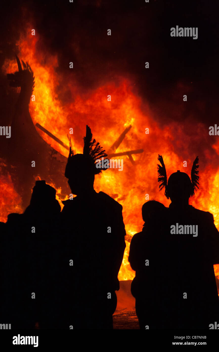 La silhouette du 'Vikings' contre un incendie Viking Cuisine à l'Up Helly Aa festival dans Lerwick sur les îles Shetland. Banque D'Images