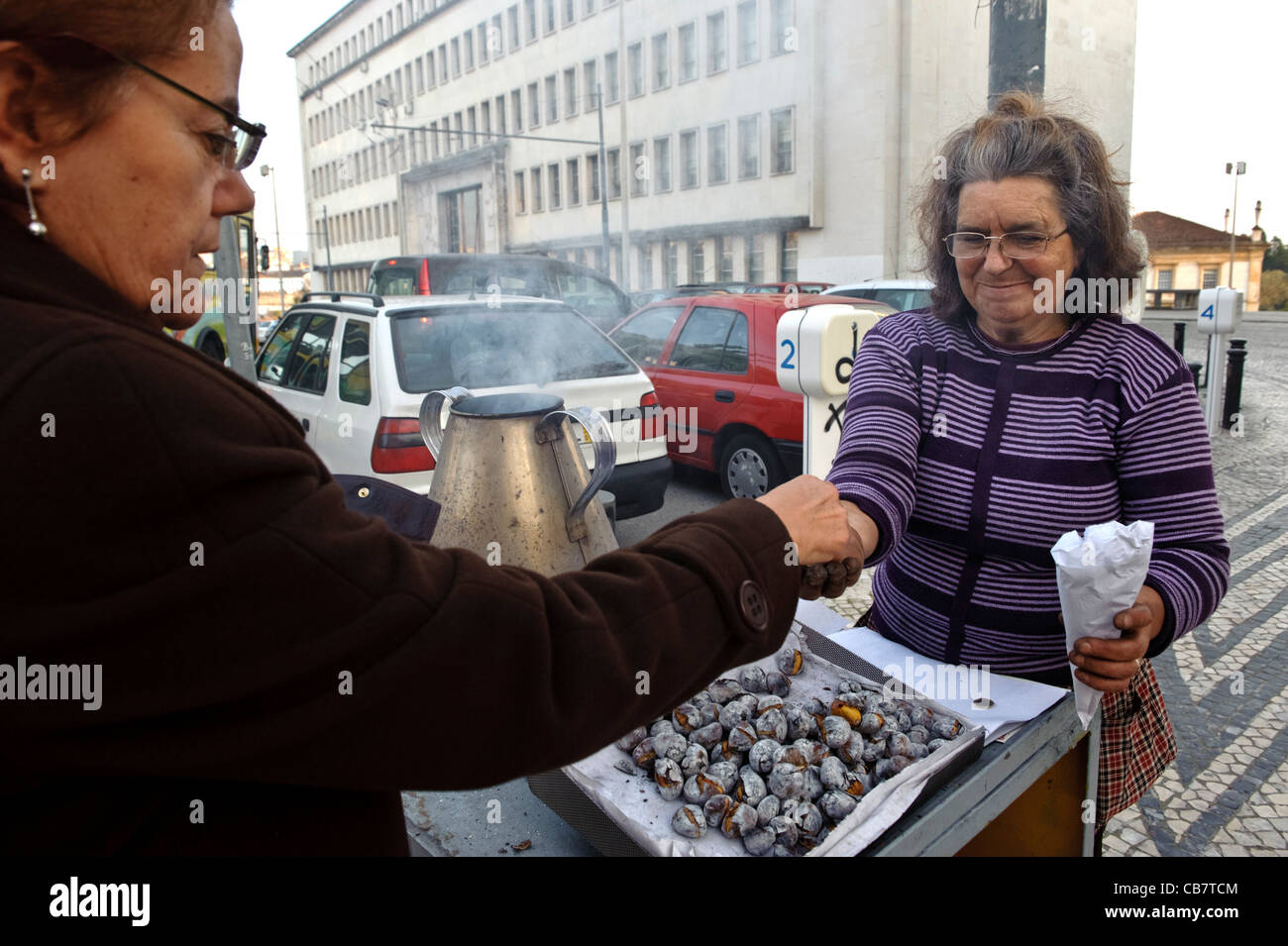 Le client paie un vendeur de rue traditionnelle vente de châtaignes grillées au Portugal Banque D'Images