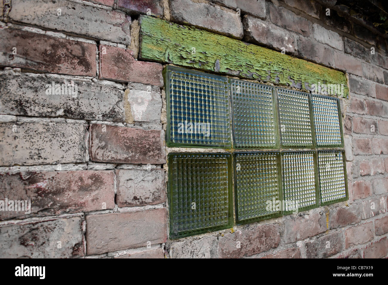 Un vieux mur avec fenêtre bloc de verre et de bois rotation lintol Banque D'Images