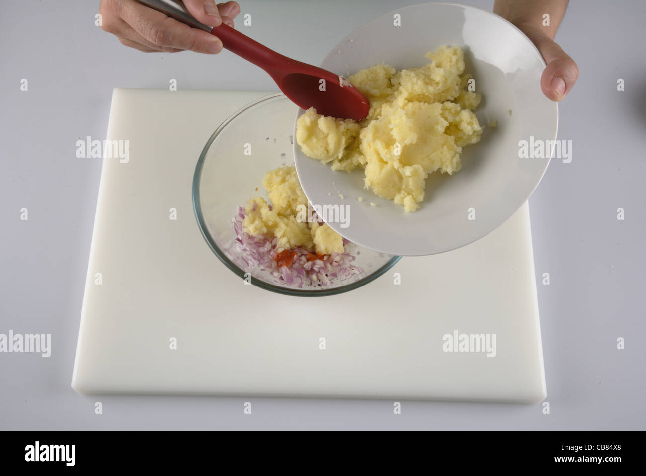 Mélanger les pommes de terre avec l'oignon haché Banque D'Images