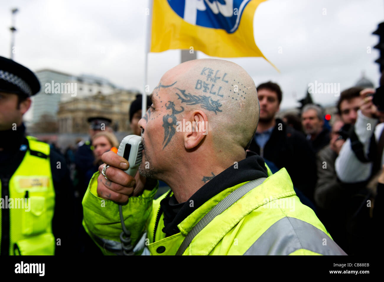 Manifestant mâle à tête avec tête tatouée avec 'Kill Bill' parle dans le microphone dans une tentative d'aiguillonner la police à protester. Banque D'Images