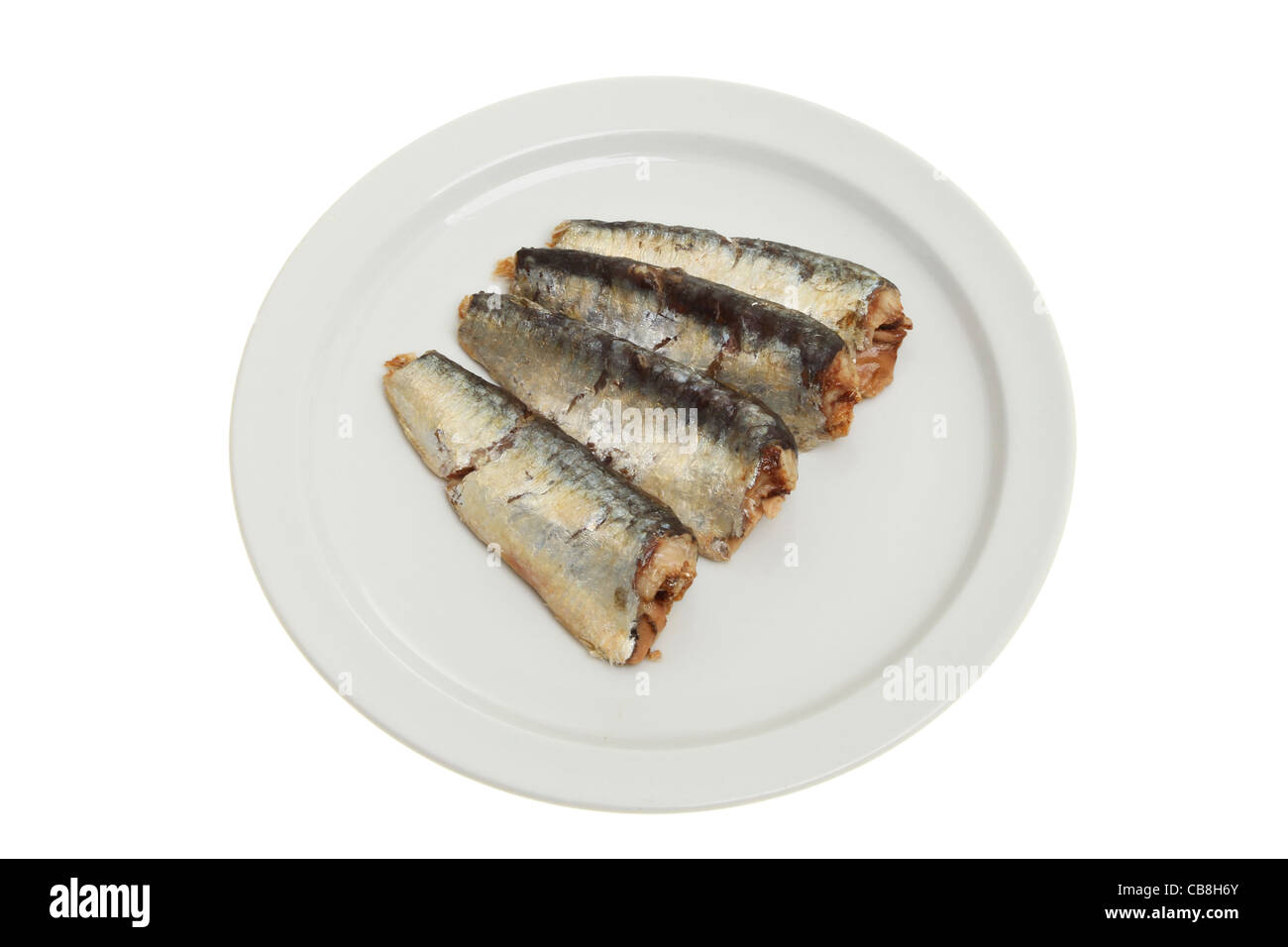 Sardines cuites sur une assiette blanche contre isolés Banque D'Images