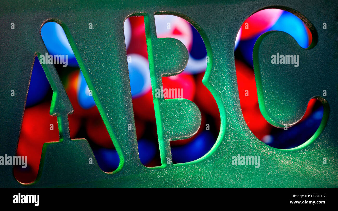 Lire et écrire des lettres ABC trace aide alphabet Pochoir Pochoir gabarit en close up avec fond coloré Banque D'Images
