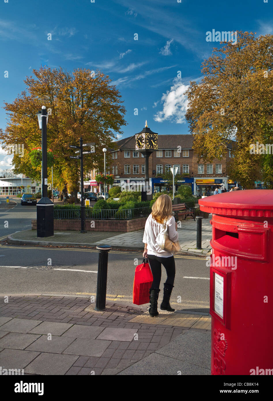 High Street Cobham Surrey post box female shopper avec designer panier Banque D'Images