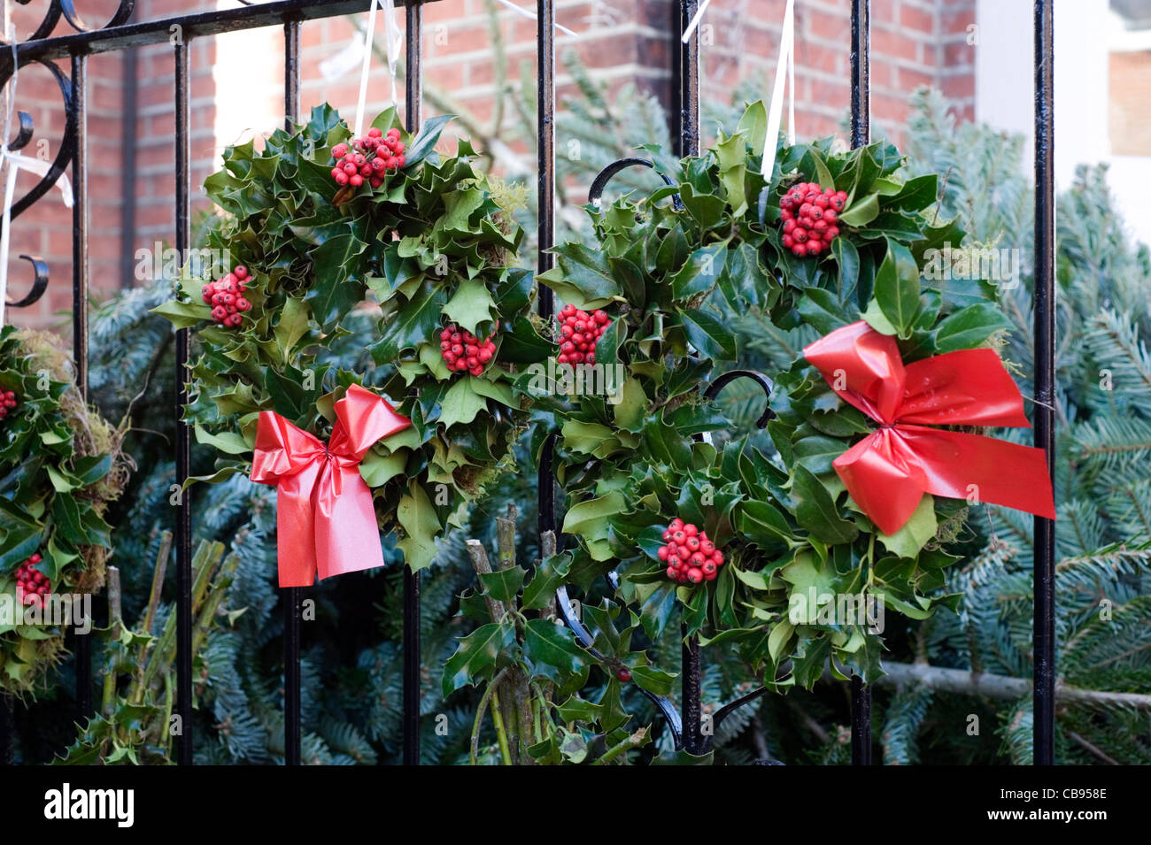 Couronne de houx la pendaison pour vendre à un marché de l'arbre de Noël Banque D'Images