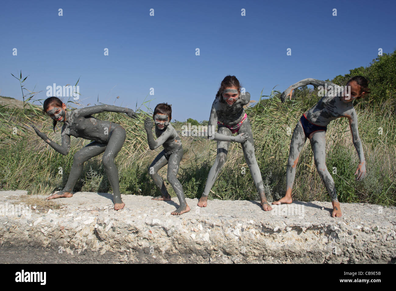 Enfants recouverts d'une boue curative jouer sur la plage, près de resort Tuzlata ville de Balchik, côte de la mer Noire, Bulgarie Banque D'Images